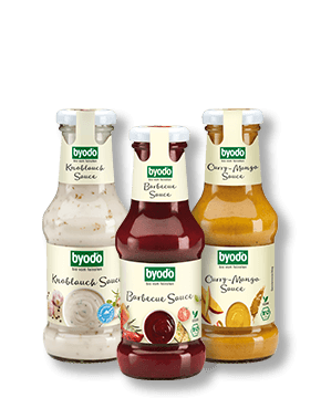 Composing der Byodo Knoblauchsauce, Barbecue Sauce und Curry-Mango Sauce im Glas auf transparentem Hintergrund
