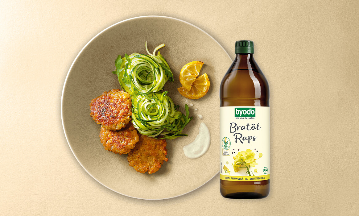 Byodo Bratöl Raps vor einem Teller mit Linsenbratlingen und Zuccini